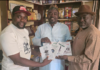 Alh.Yshauu Shuaib presenting books to Dr. Anthony Ogande and Dr. Ukam I. during a visit in Abuja